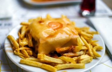 Delicious traditional francesinha served with french fries, Porto, Portugal